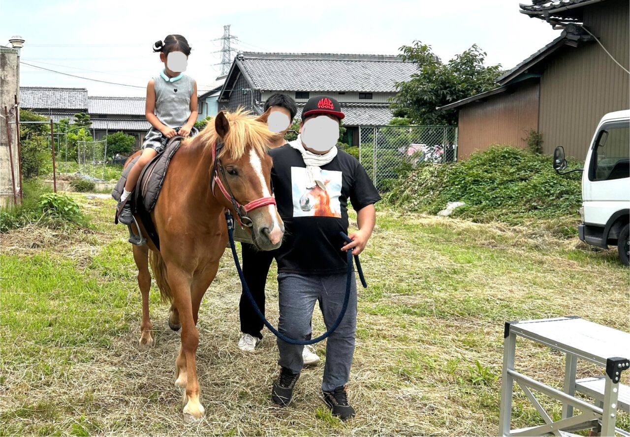 あいさいベース会場でポニーの乗馬体験をする子ども