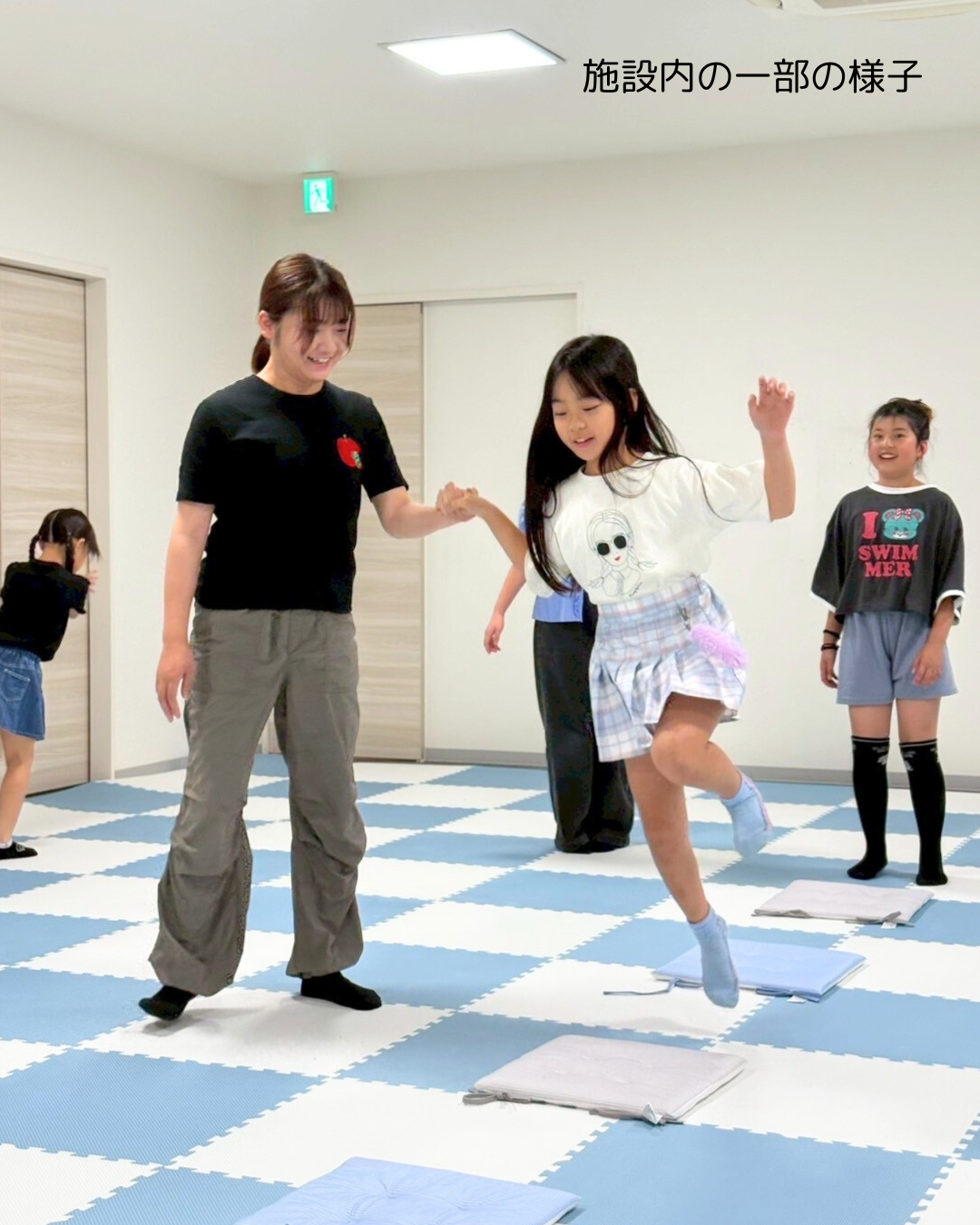 施設内でジャンプ運動を行う子どもと支援スタッフの様子