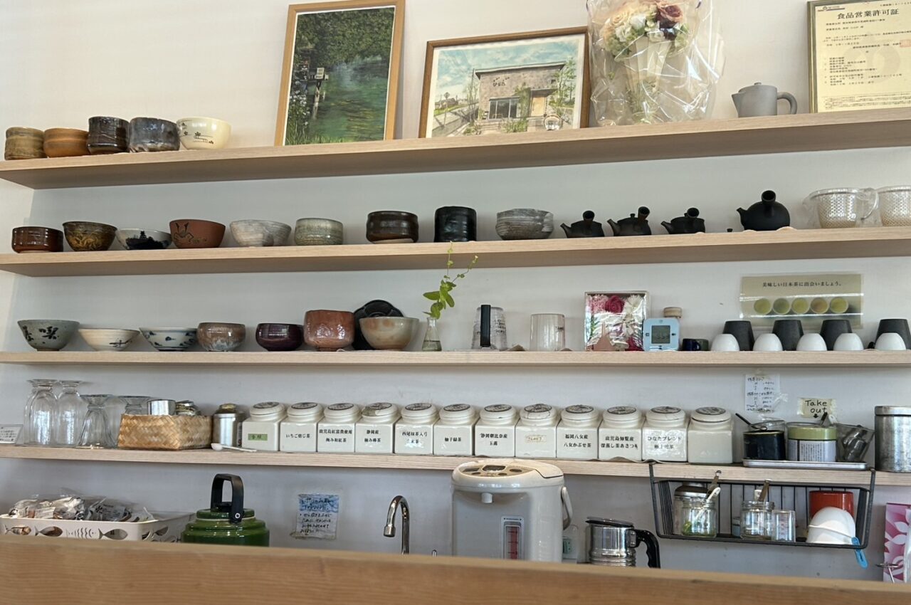 茶碗や急須、茶葉缶が整然と並ぶ茶菓専科ひなたのカウンター棚の様子