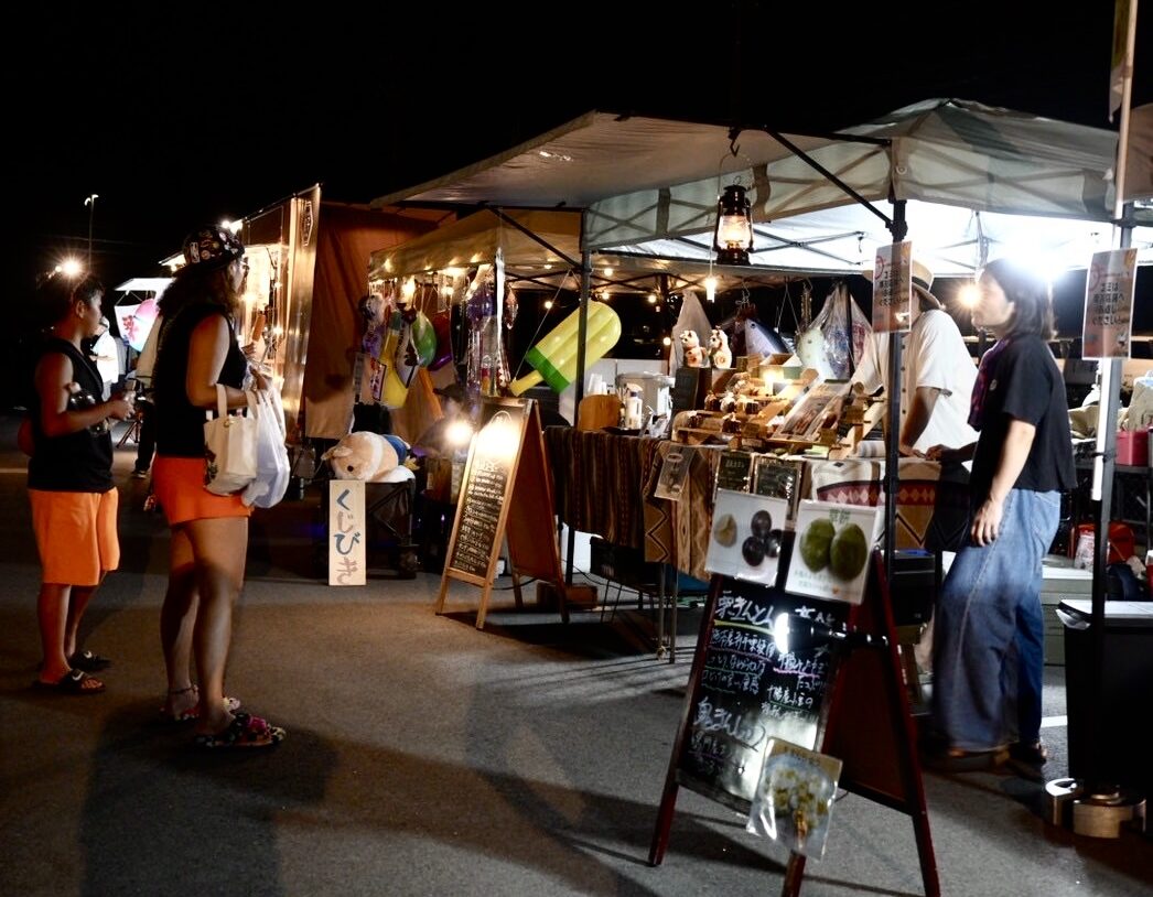 ライトアップされた夜の出店ブースと来場者