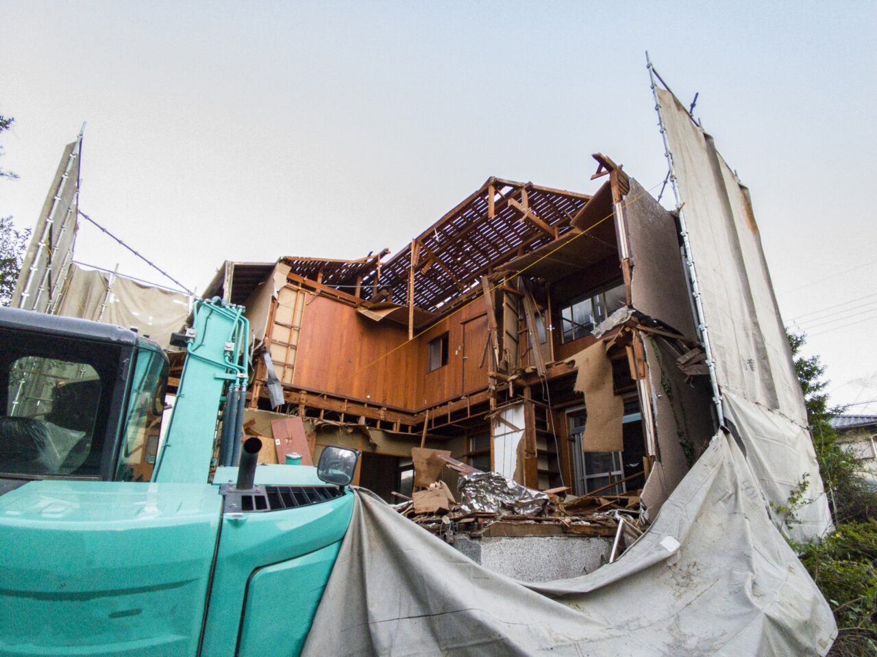 重機が建物を取り壊す解体工事現場の様子