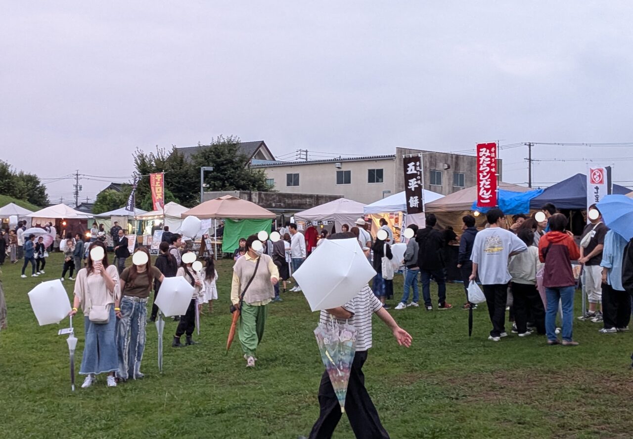 屋台と傘を差した来場者の風景