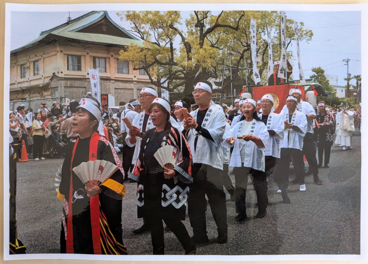 神事行列で木遣り唄を奉納する漆部神社木遣保存会の行進の様子