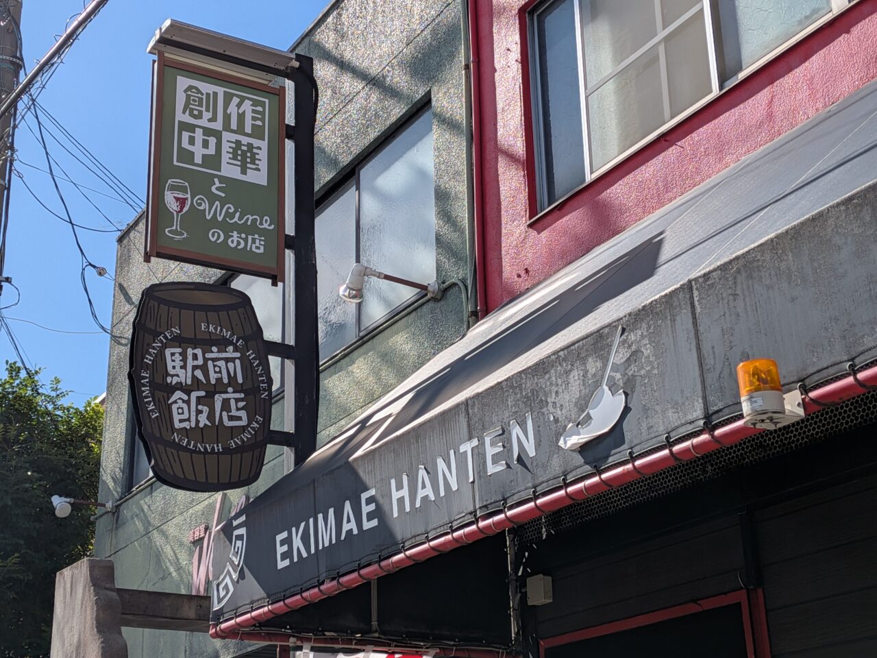 駅前飯店の店頭に設置された「創作中華とワインのお店」の看板と店舗外観