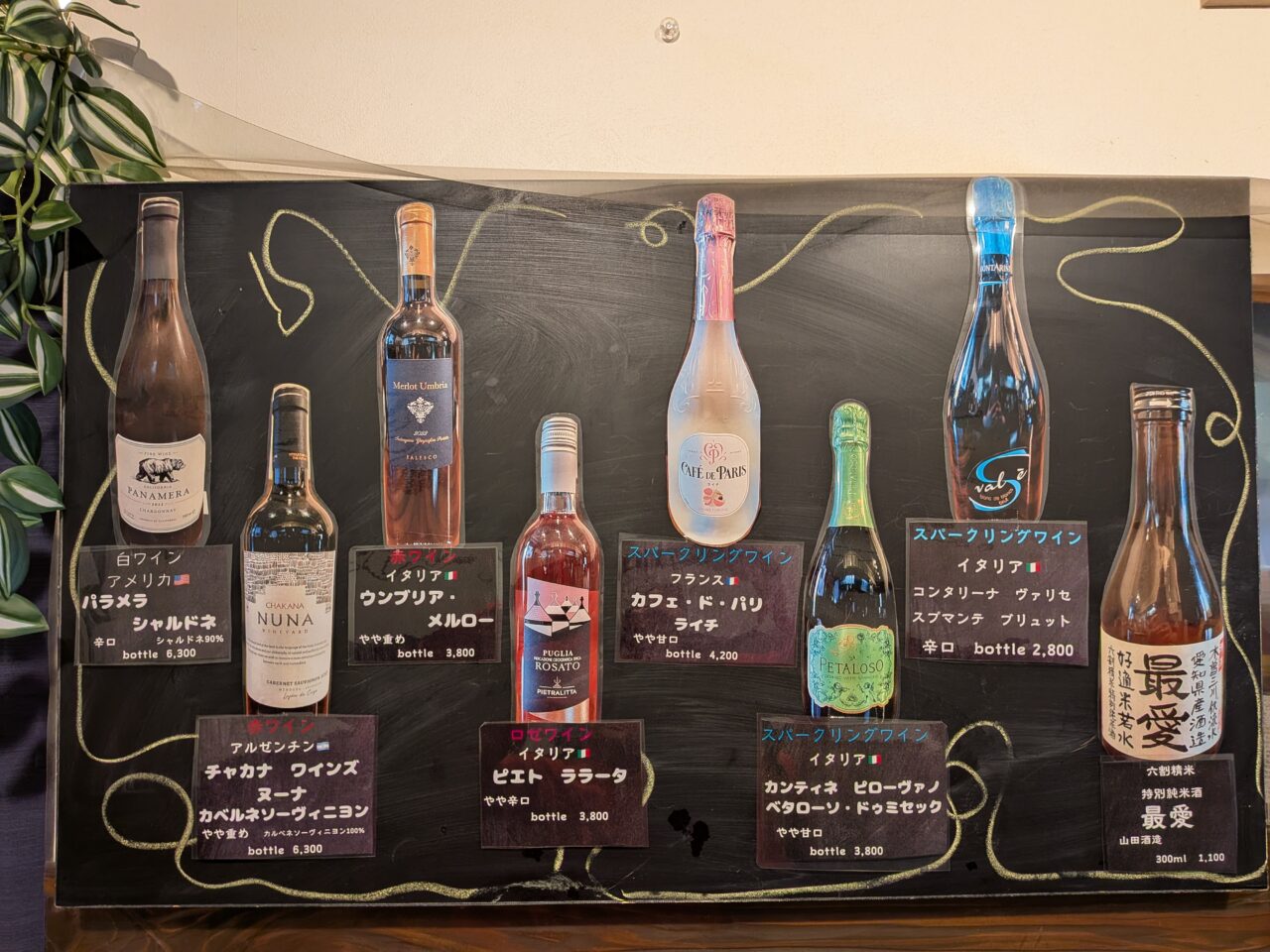 店内に掲示された各種ワインと日本酒のボトル写真