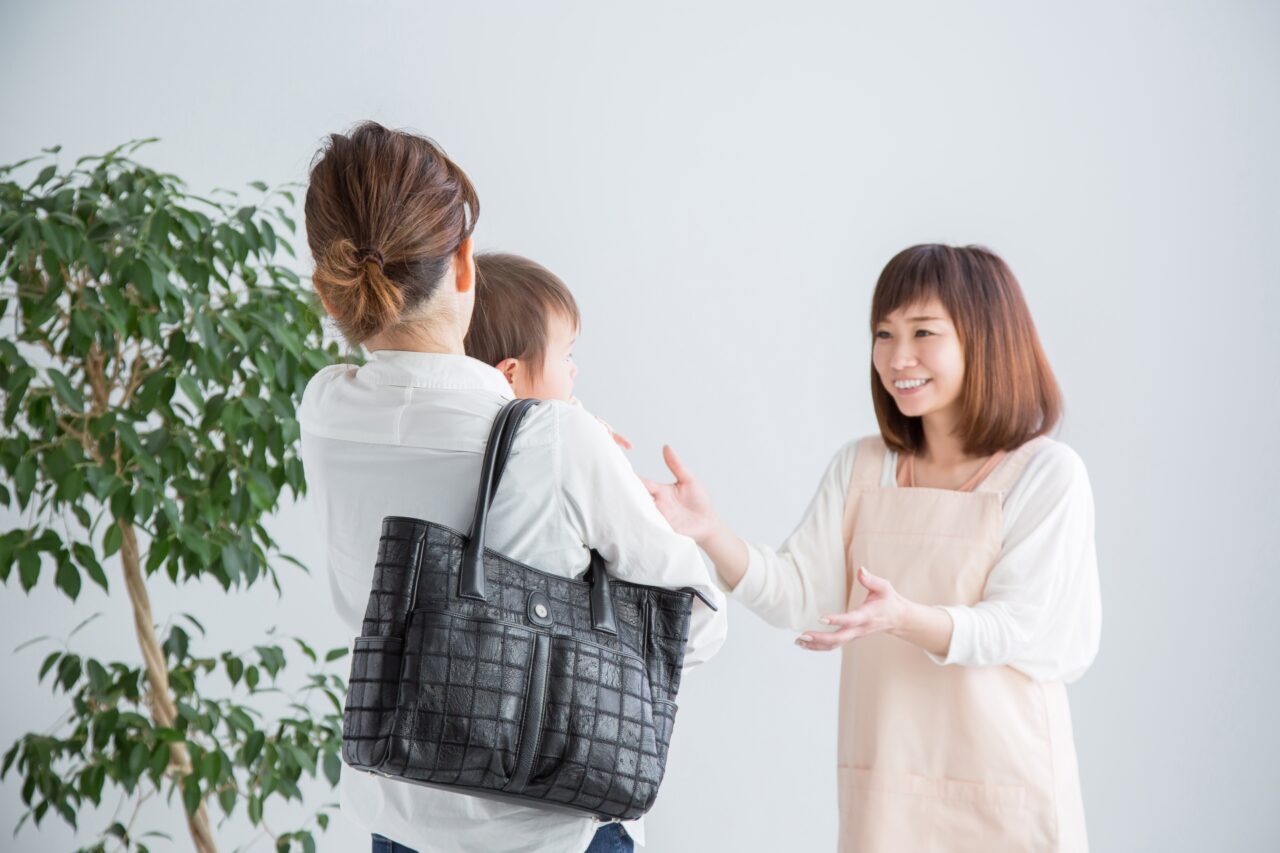 子どもを連れた保護者と話すボランティアスタッフのイメージ写真