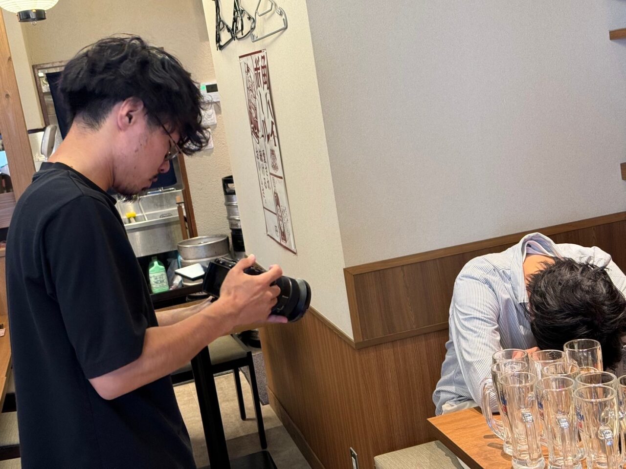 飲食店のテーブル越しに映像を撮影するクリエイターの様子