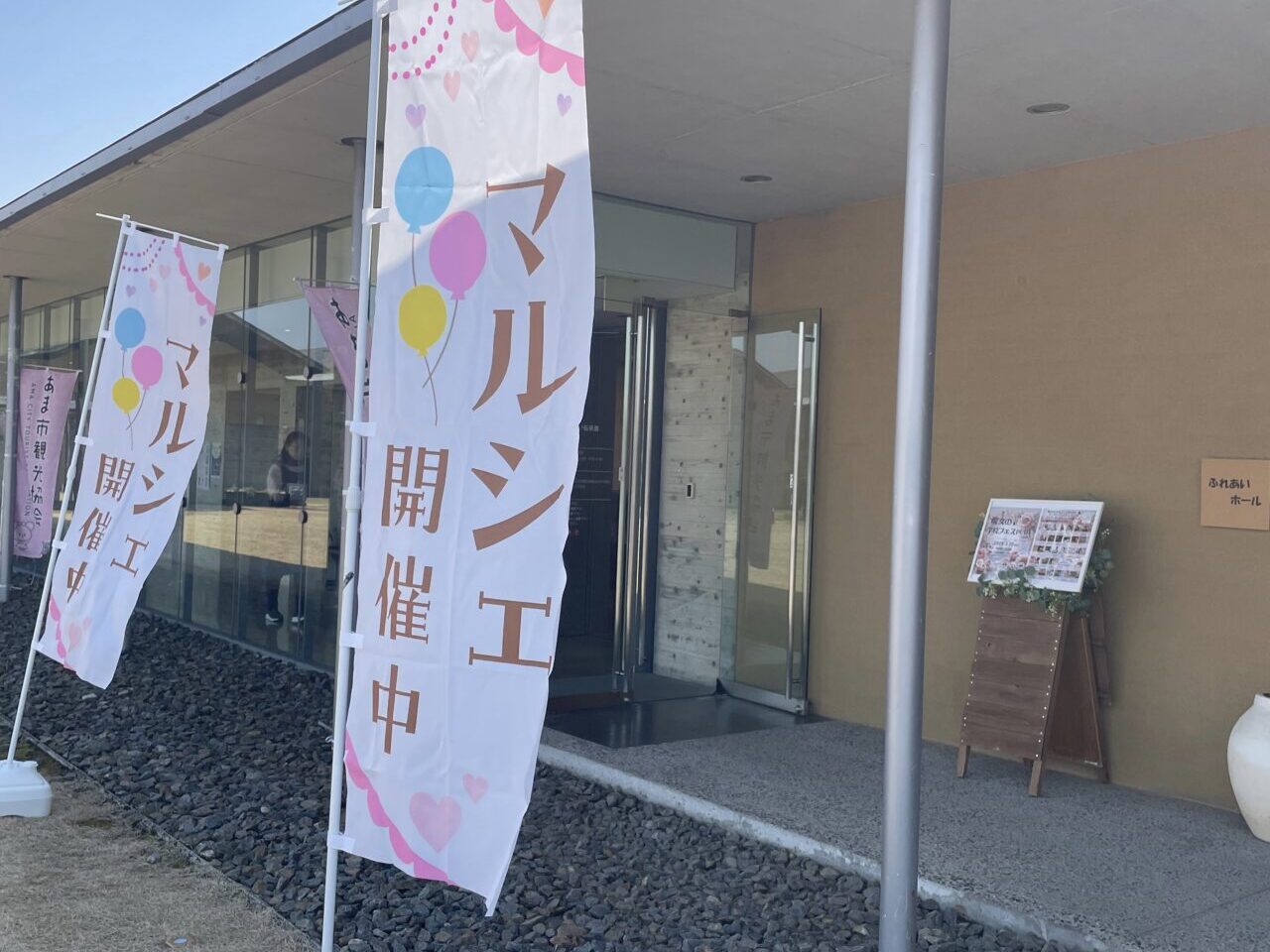 七宝焼アートヴィレッジの「あま市 ふれあいホール」入口に掲げられたマルシェ開催中の旗と案内看板
