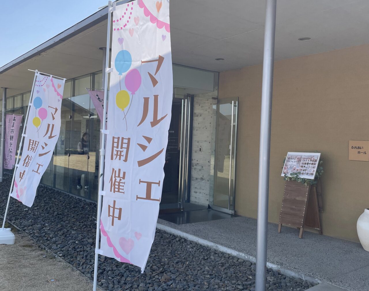 七宝焼アートヴィレッジの「あま市 ふれあいホール」入口に掲げられたマルシェ開催中の旗と案内看板