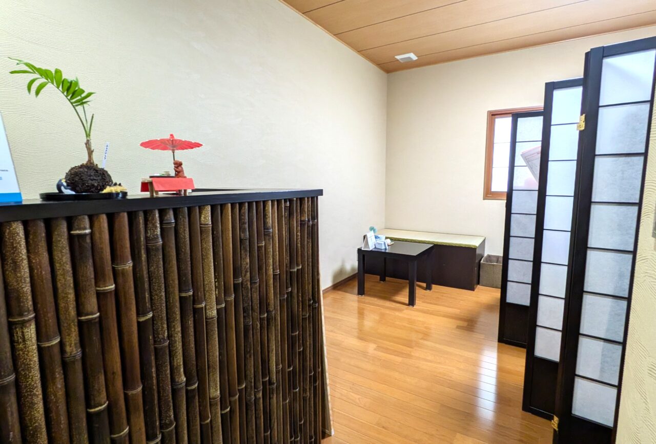 健向美人の受付と待合スペース。竹のカウンターと和風の仕切りが印象的な空間