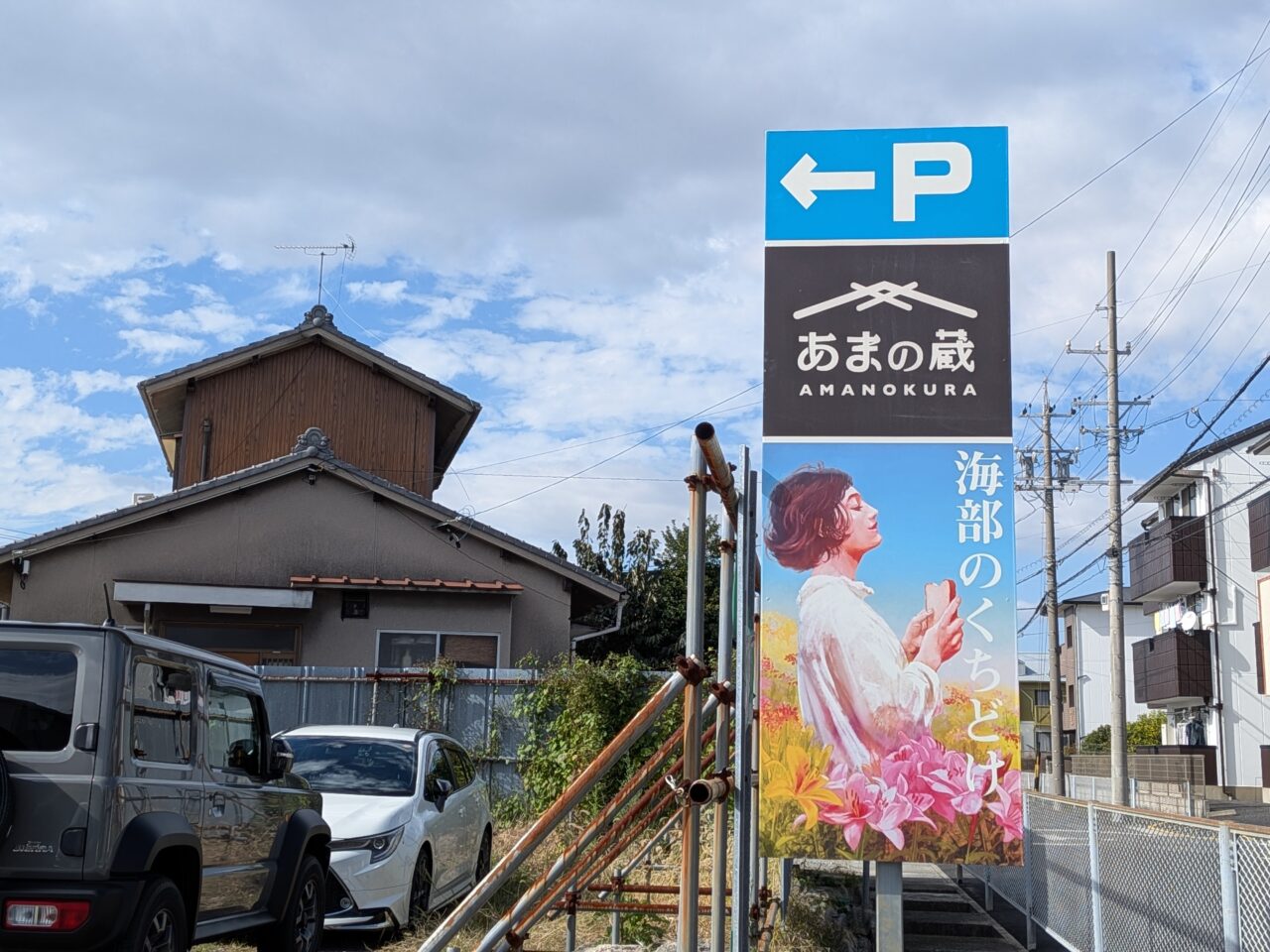 あまの蔵と海部のくちどけの駐車場案内看板。左向きのPマークと店舗名が表示されている