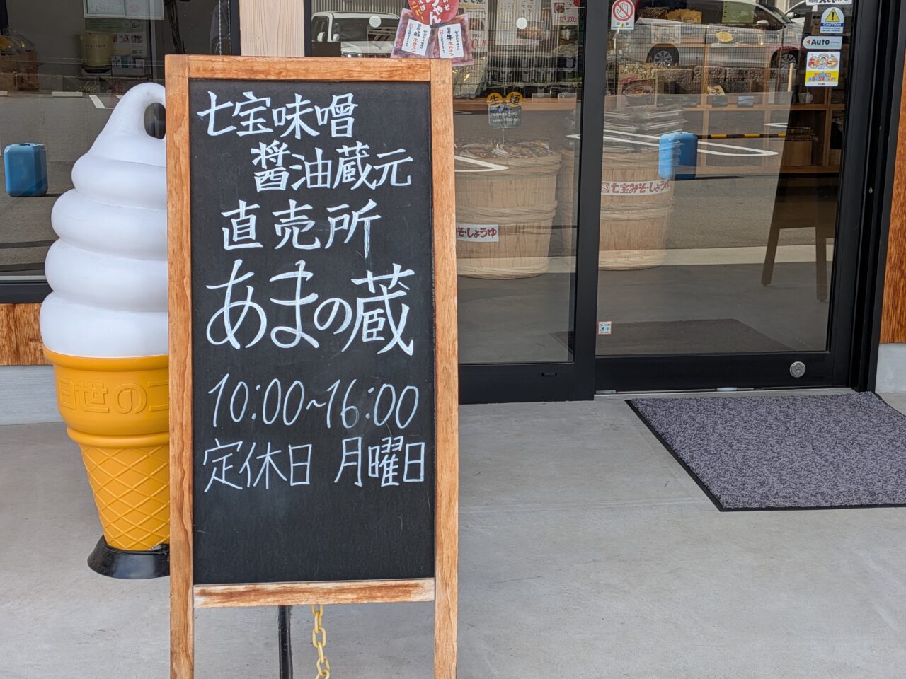 七宝味噌・醤油蔵元の直売所「あまの蔵」の営業時間と定休日を示す店舗前の黒板看板