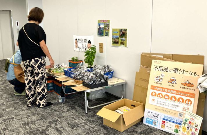 モノドネコーナーに並ぶ寄付用の不用品と掲示物