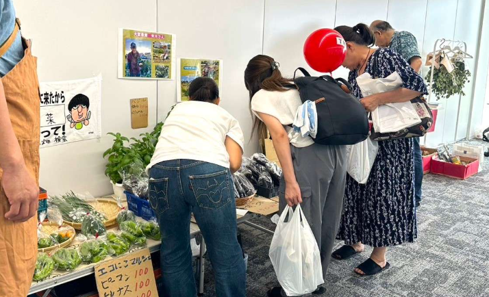 野菜を手に取って選ぶ来場者の様子