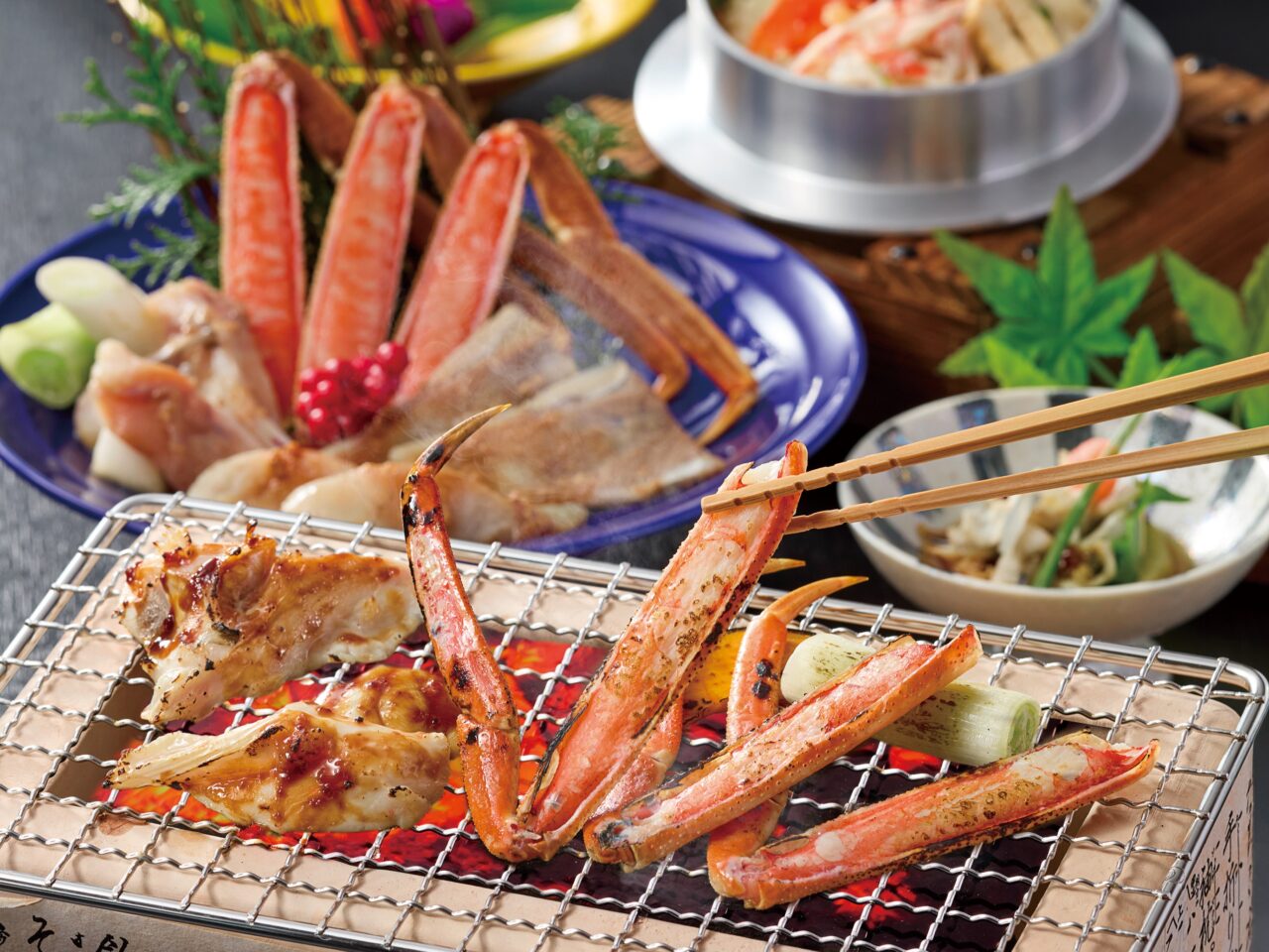 蟹とふぐの炭火焼きを網で焼く様子