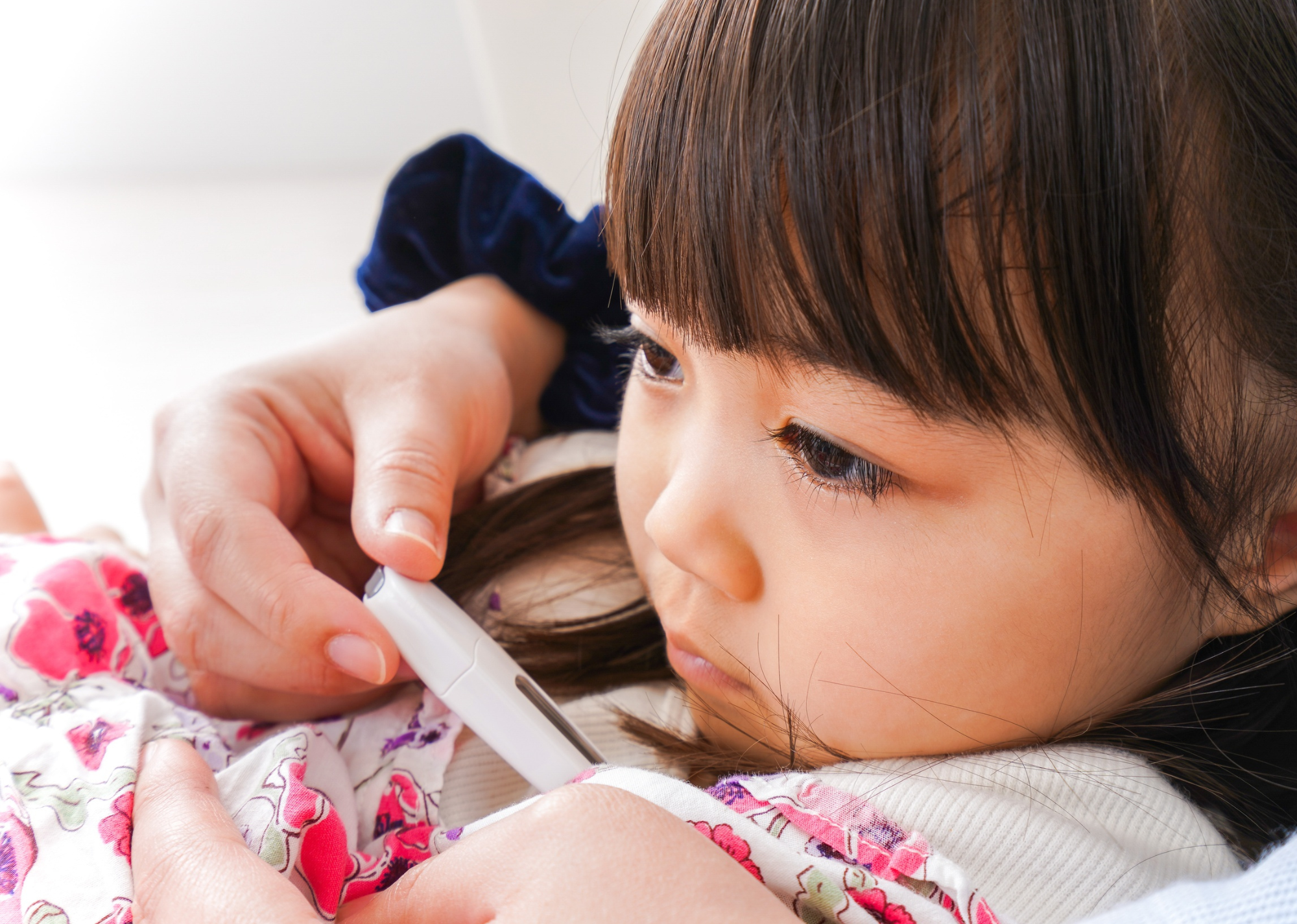 発熱した幼い子どもの体温を測っている様子のイメージ画像