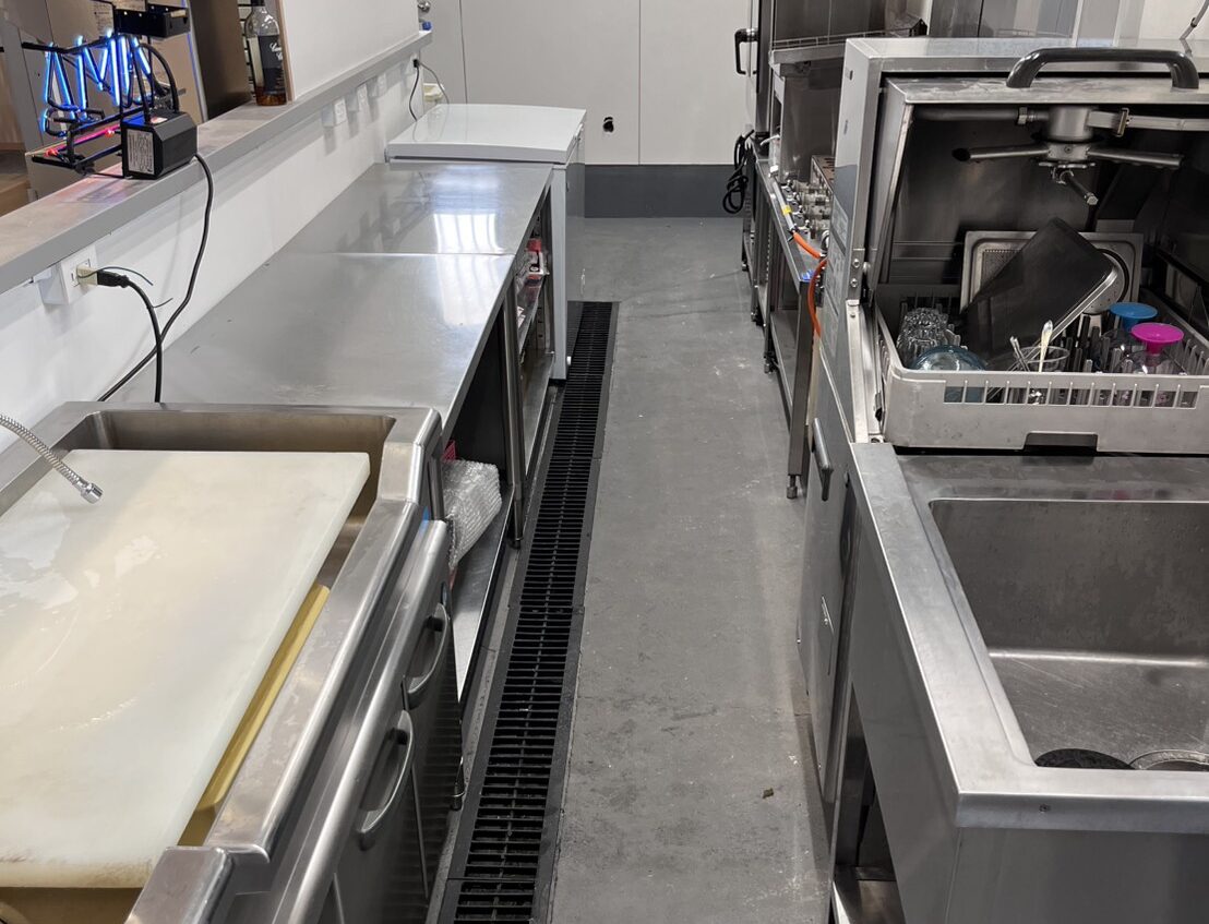 AISAI BASEの厨房裏手に並ぶ業務用食器洗浄機や作業台の様子