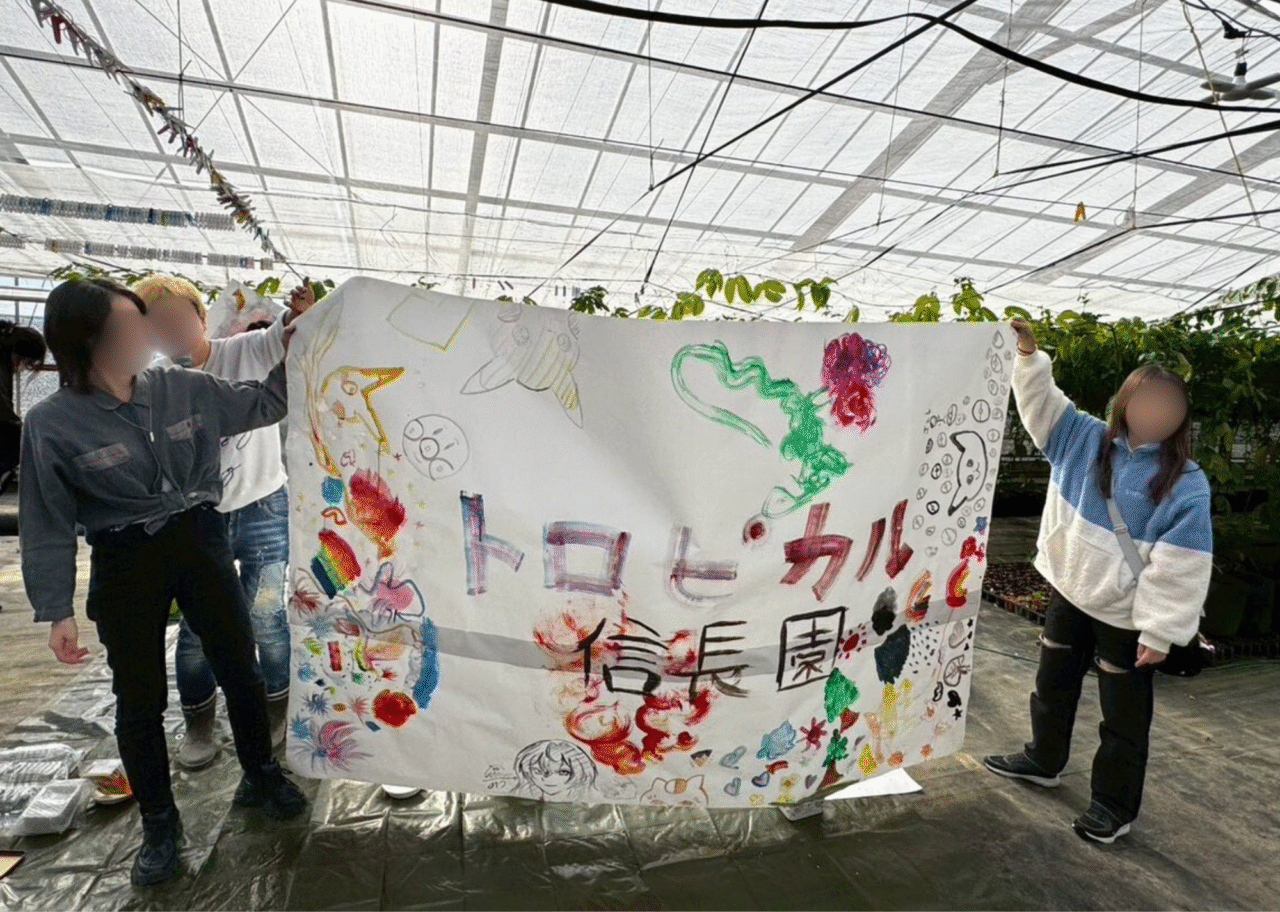 愛西市のトロピカル信長農園で過去に開催されたイベント時の様子。手作りの横断幕を持つ参加者たち