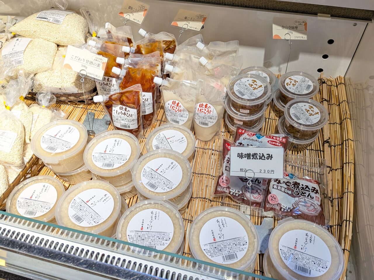 糀屋の冷蔵ケースに並ぶ味噌や甘酒の素、調味料類