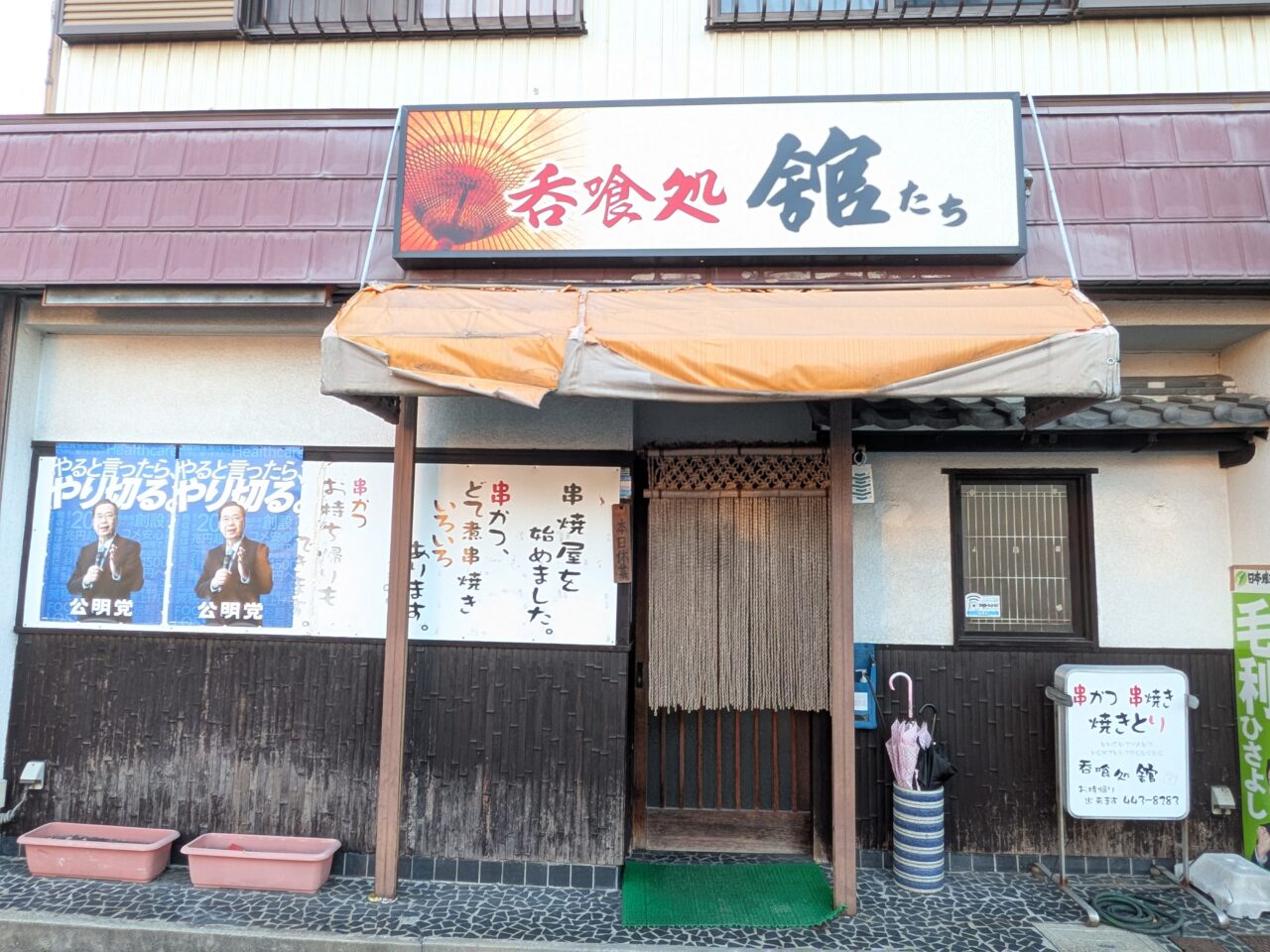 呑食処館の外観。暖簾と看板が印象的な入口