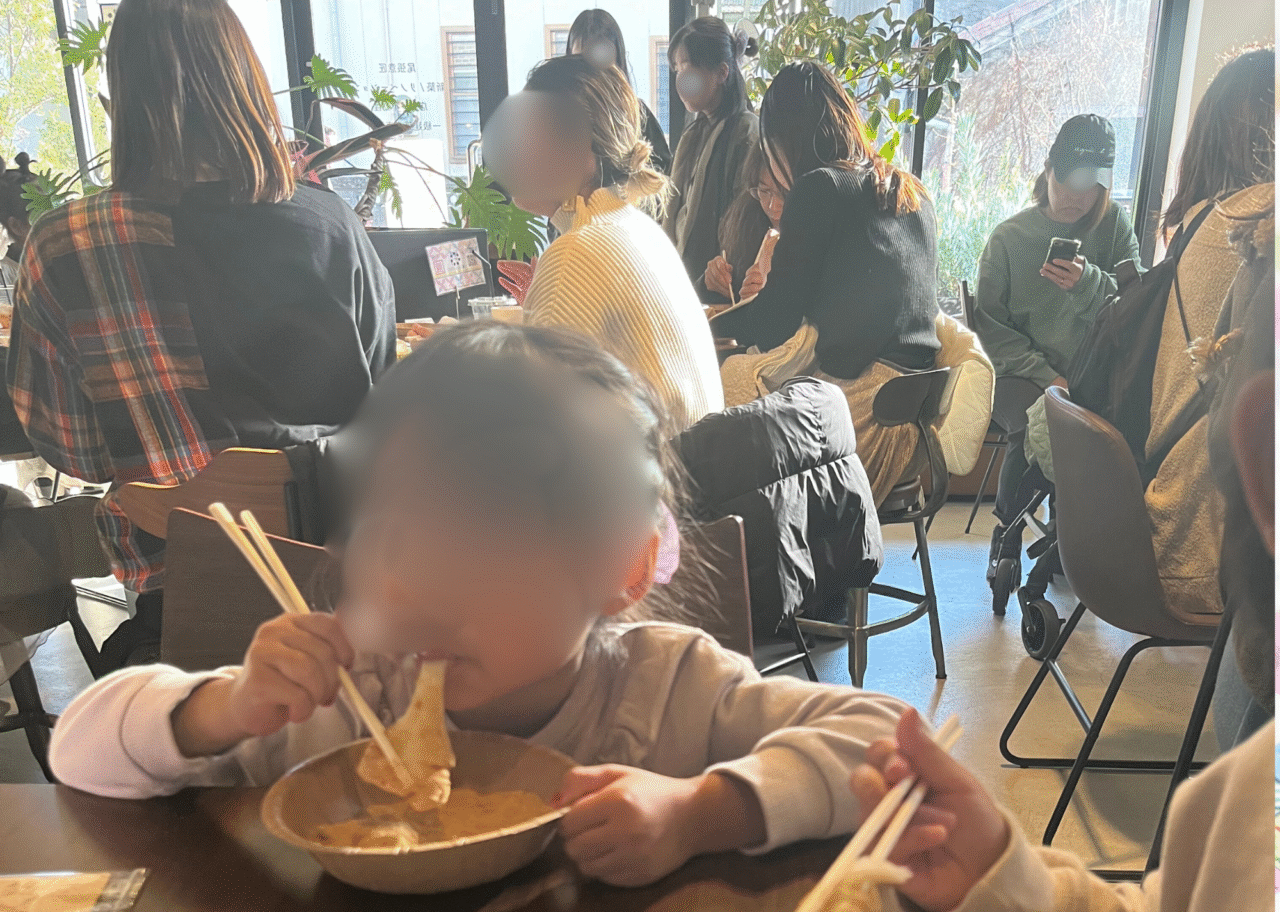 SIPPO MEET UP CAFÉ内で豚おもちを食べる子どもと賑わう店内の様子