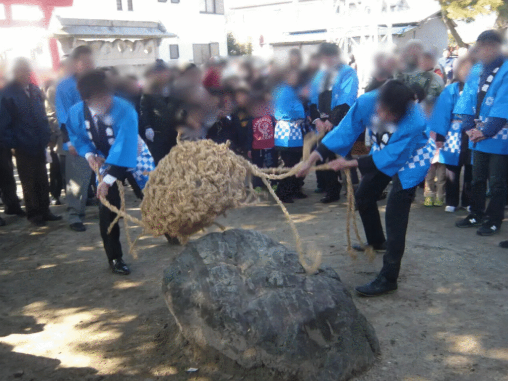 あま市七宝町下之森の下之森八幡社で行われるオコワ祭で、オコワを包んだお櫃をオコワ石に叩きつける神事の様子