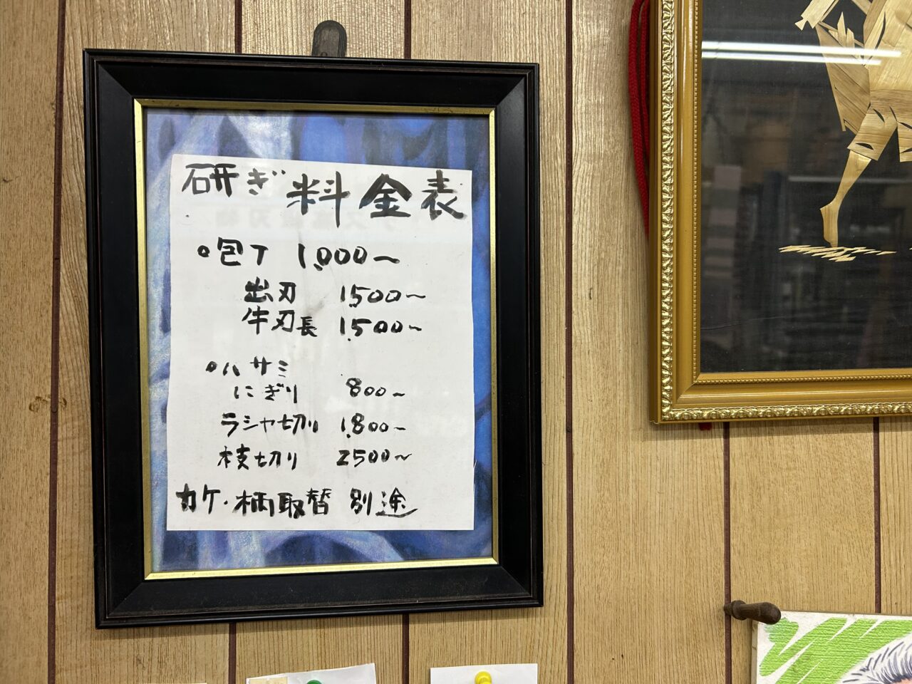 津島市天王通りの伊藤金物店店内に掲示された包丁研ぎとハサミ研ぎの税込価格表