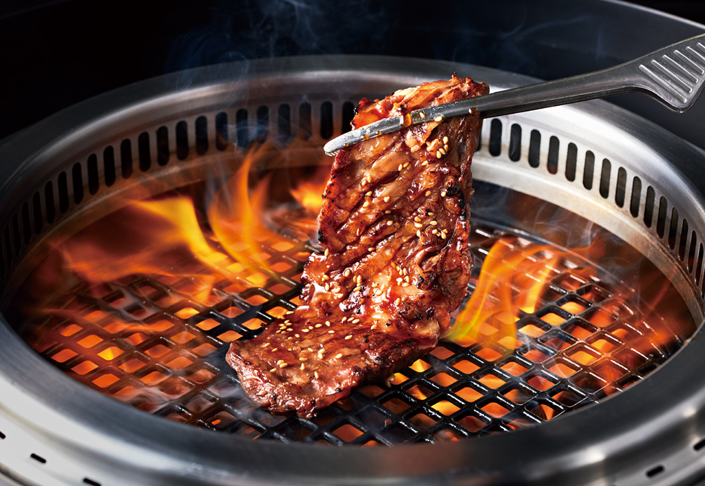 焼肉きんぐの網の上で焼かれるカルビと炎の様子