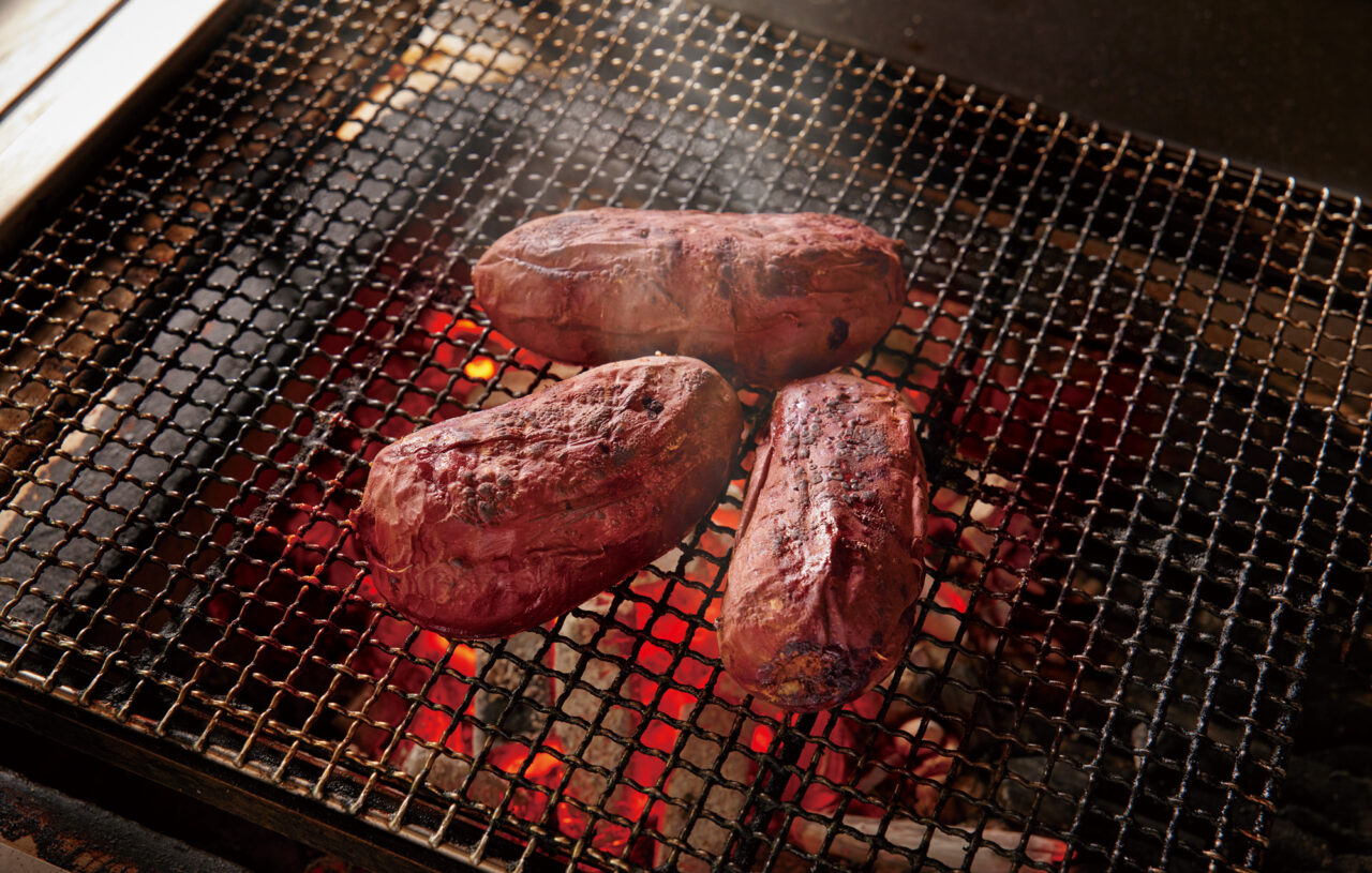 炭火で焼かれている焼き芋の様子