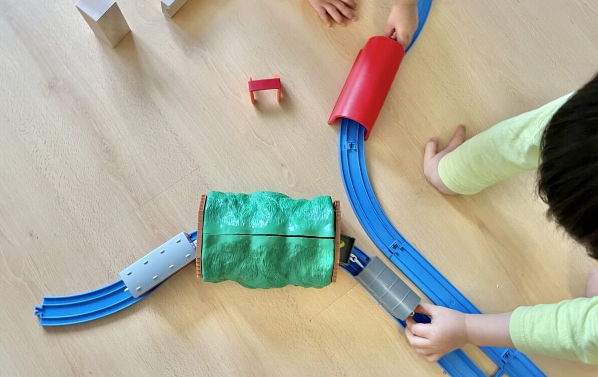 鉄道おもちゃを走らせて遊ぶ子供たちの様子のイメージ画像