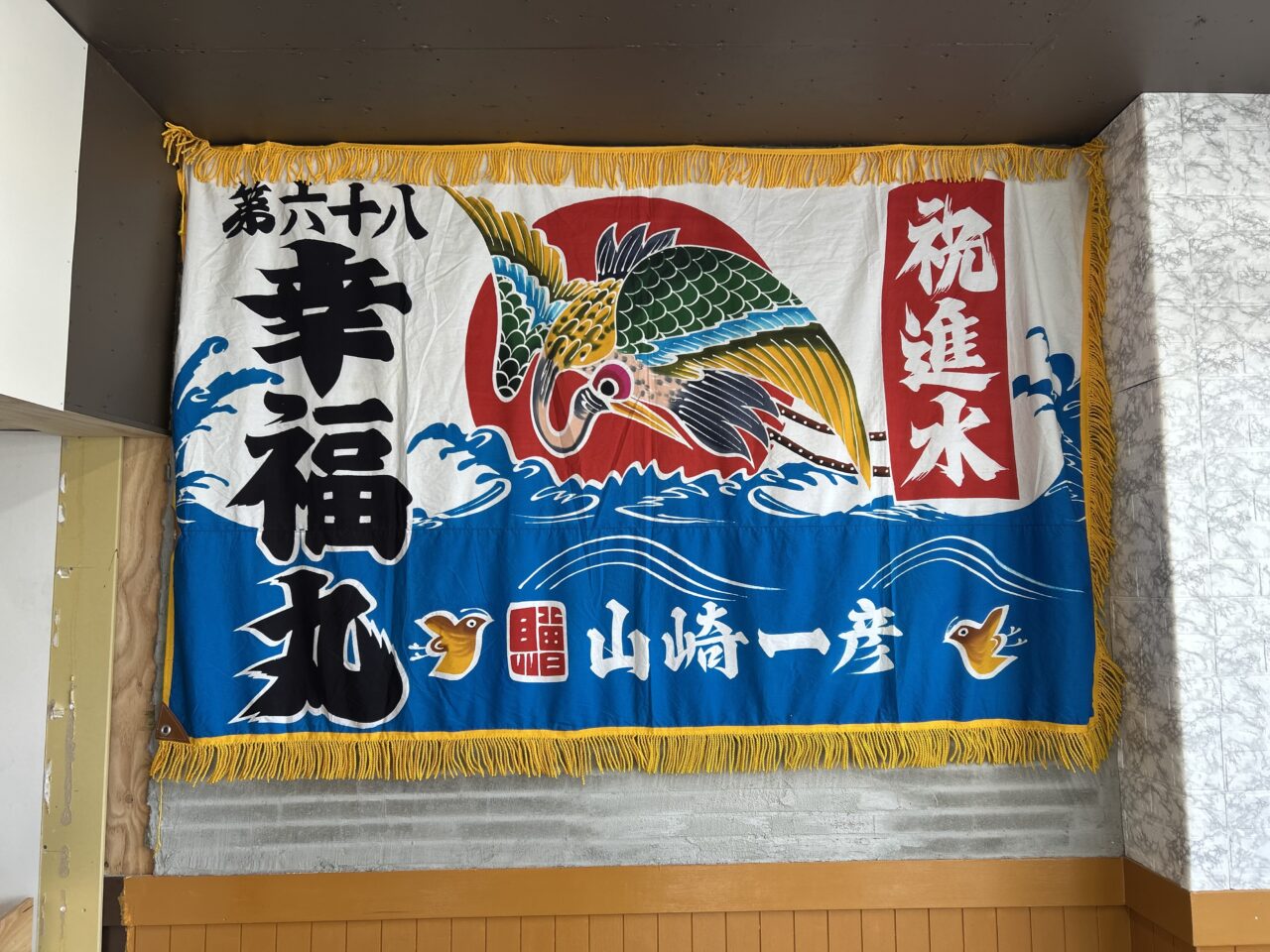 サカナベースあま店の店内に飾られた第六十八幸福丸と書かれた大漁旗